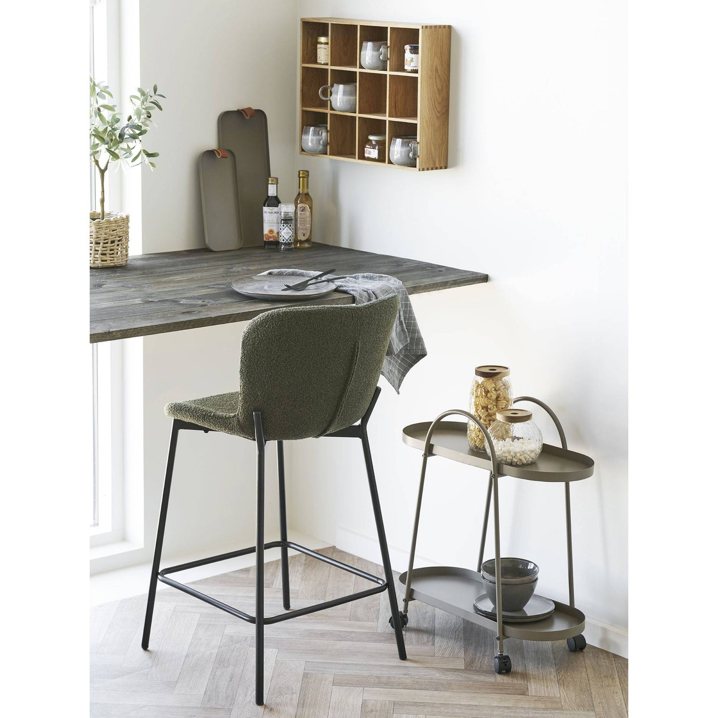 Scaun de bar din material bouclé, verde, cu picioare negre, in living scandinav