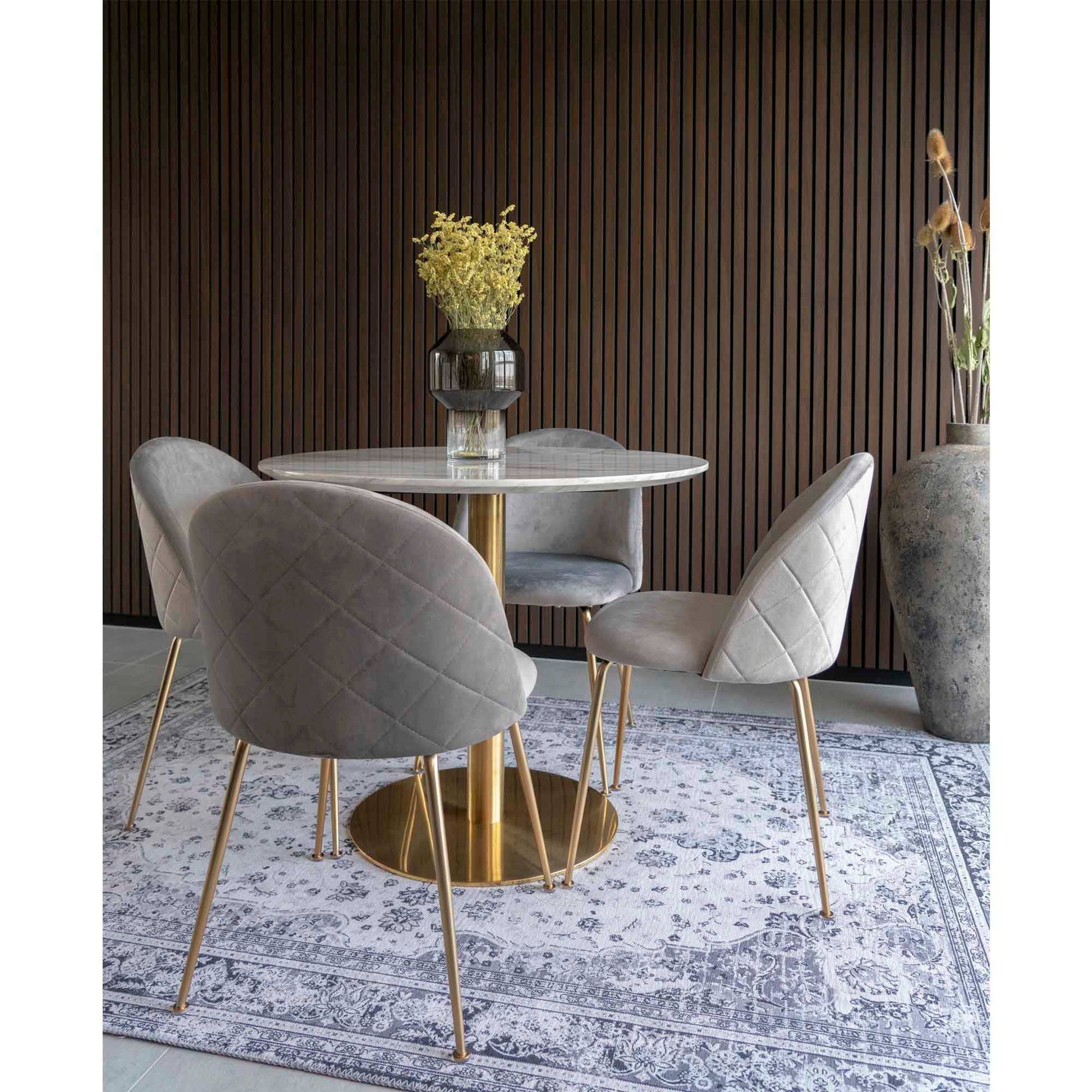 Masa de dining cu blat cu aspect de marmura, baza cu aspect alama, in living