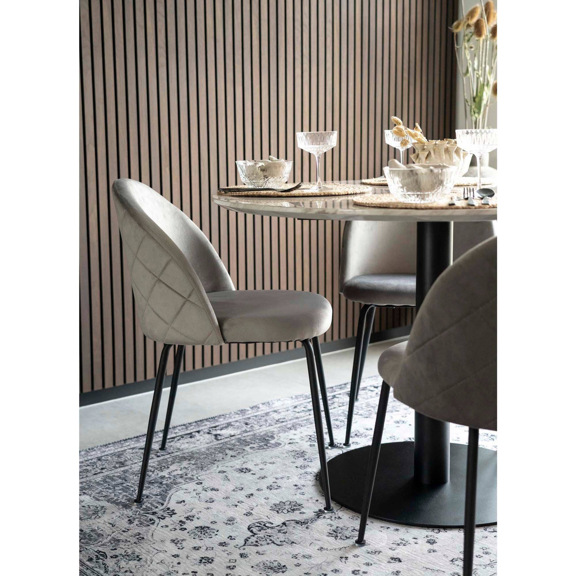 Masa de dining cu blat cu aspect de marmura, baza neagra, in living