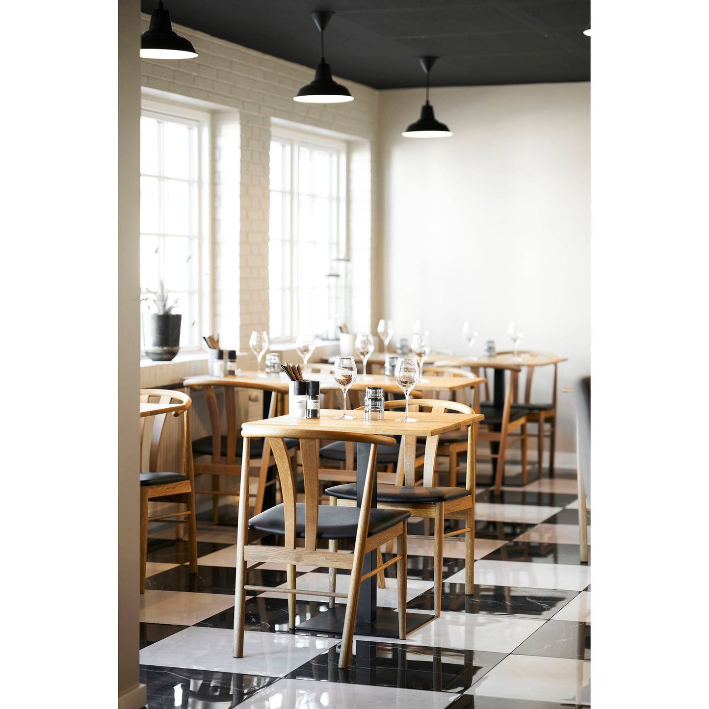 Masa de cafea din stejar, baza neagra din metal, in cafenea