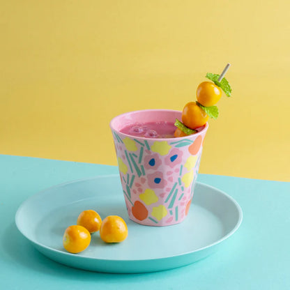 pahar multicolor cu imprimeu floral, asezat pe farfurie