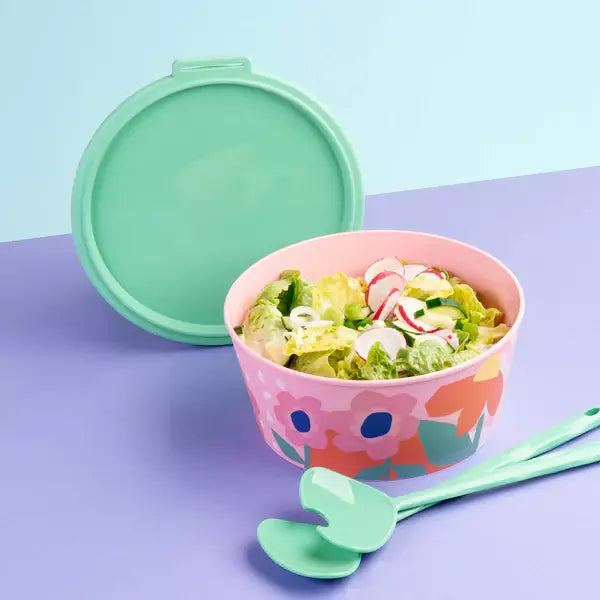 Cutie alimentara cu imprimeu floral si capac verde, continand salata, pe fundal multicolor